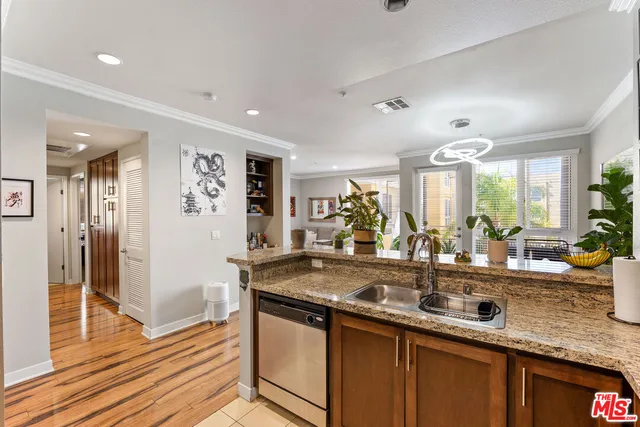 a kitchen with stainless steel appliances granite countertop a sink and a refrigerator