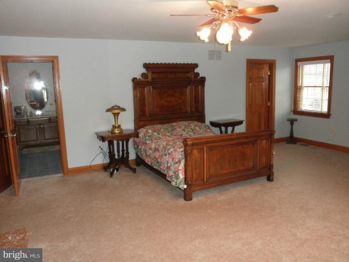 3995 Perry Hall Road Perry Hall, MD 21128 - Photo 17 of 26 a bedroom with a bed and a chandelier