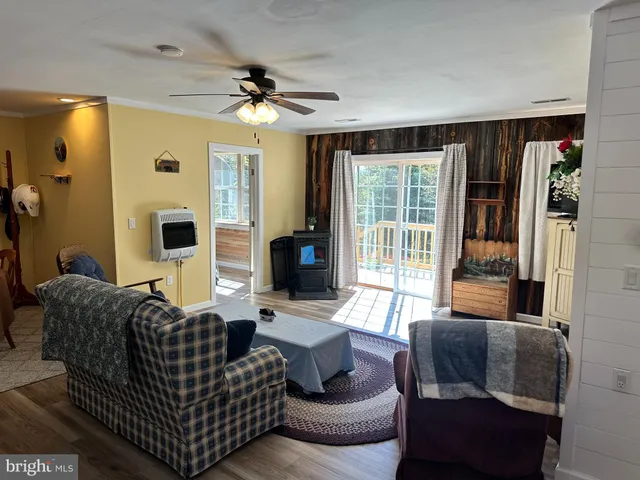 a living room with furniture two window and a flat screen tv
