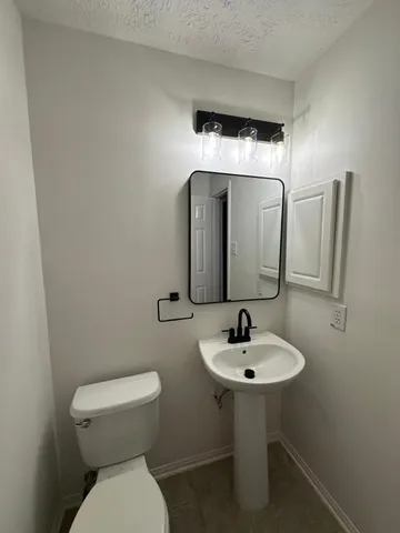 a bathroom with a toilet sink and mirror
