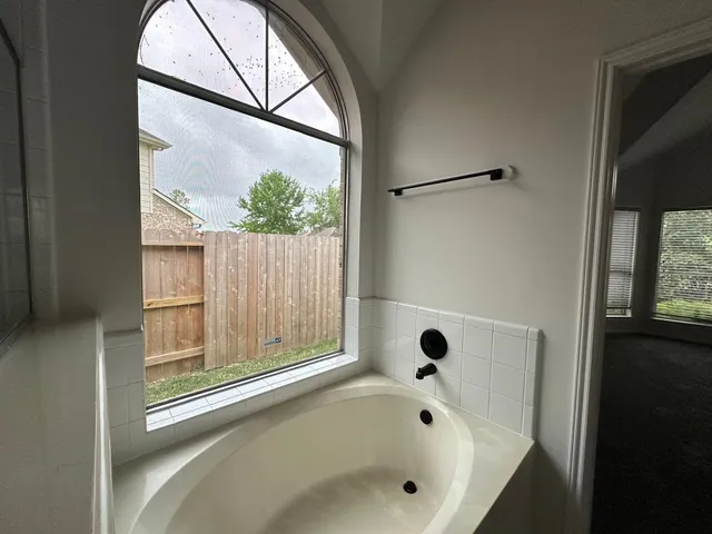 a bathroom with a bathtub and a window