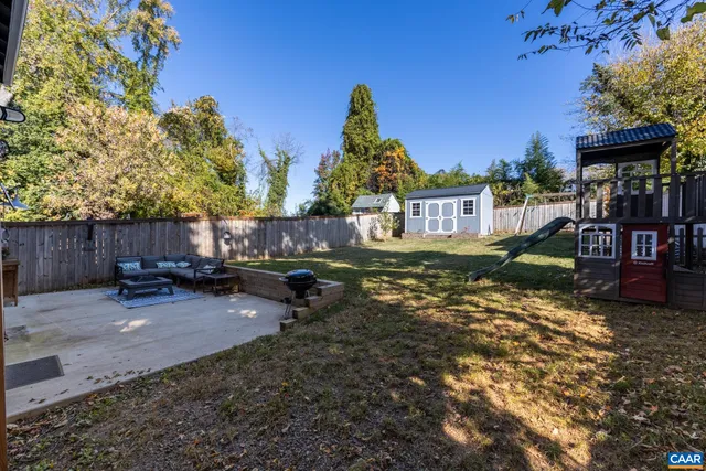 a view of backyard with deck and a slide