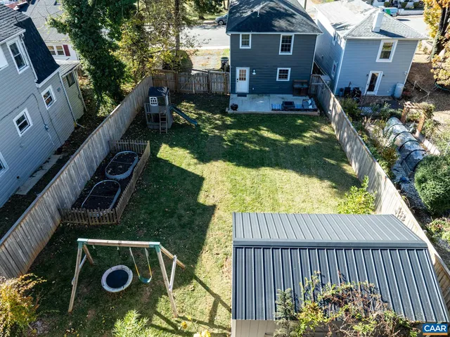 a view of backyard with deck and a slide