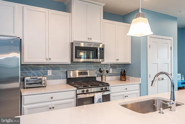 a kitchen with granite countertop a stove a sink and a microwave
