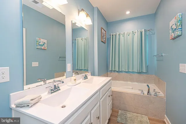 a bathroom with a tub sink and mirror