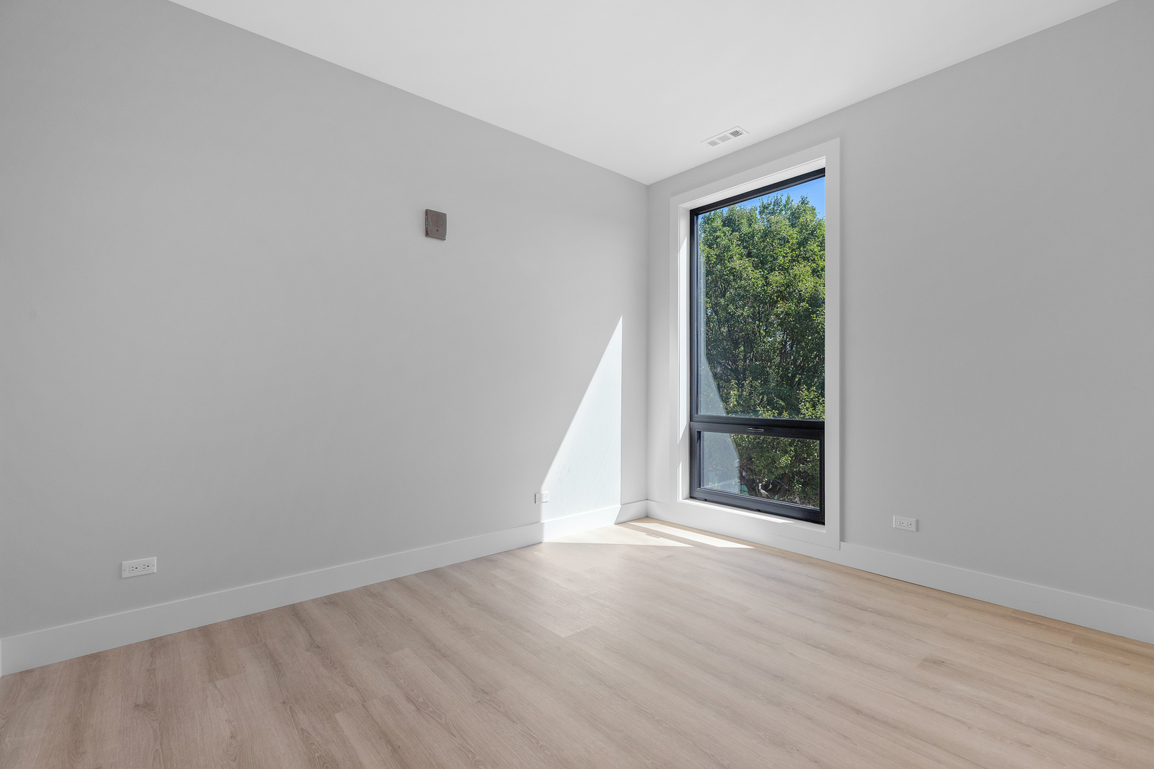 3953 West Dakin Street, Unit 405 Chicago, IL 60618 - Photo 14 of 21 wooden floor in an empty room with a window