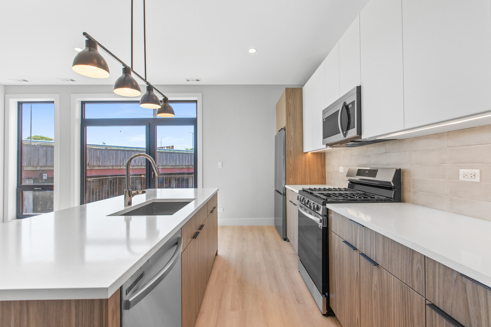 3953 West Dakin Street, Unit 405 Chicago, IL 60618 - Photo 8 of 21 a kitchen with a sink a stove and cabinets