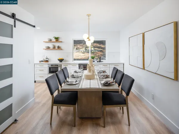 a view of a dining room and livingroom with furniture wooden floor a chandelier