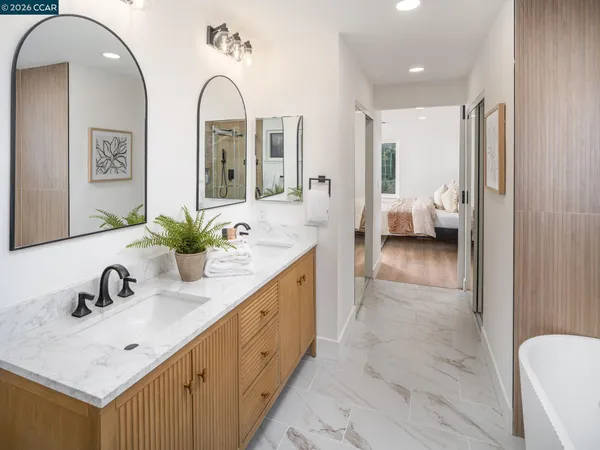 a bathroom with a double vanity sink mirror and bathtub