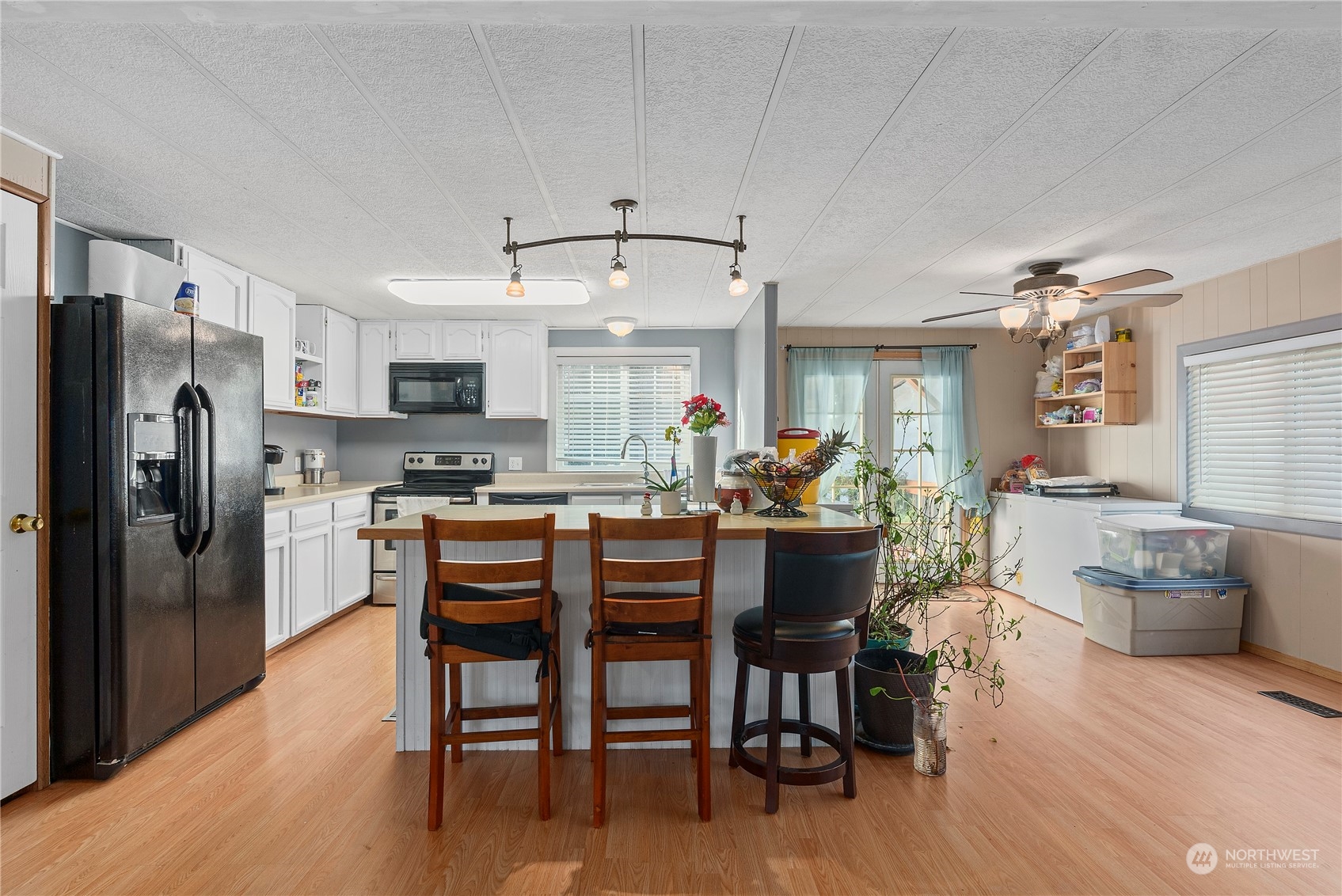 267 Limmer Road Winlock, WA 98596 - Photo 7 of 25 a kitchen with stainless steel appliances granite countertop a refrigerator a stove a sink a dining table and chairs with wooden floor