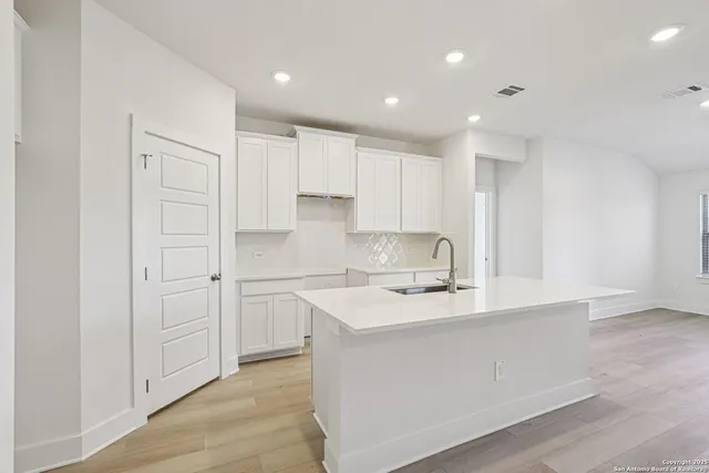 a kitchen with kitchen island white cabinets and stainless steel appliances
