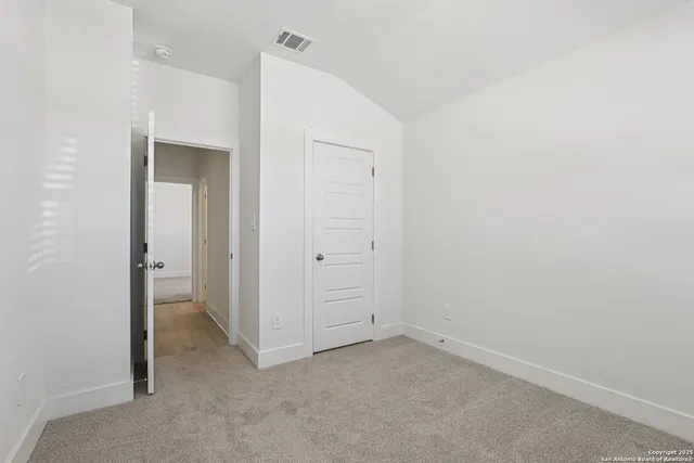 an empty room with closet and a bathroom