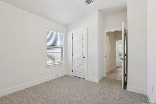 an empty room with windows and closet