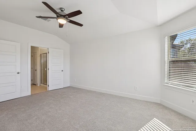 an empty room with windows and fan