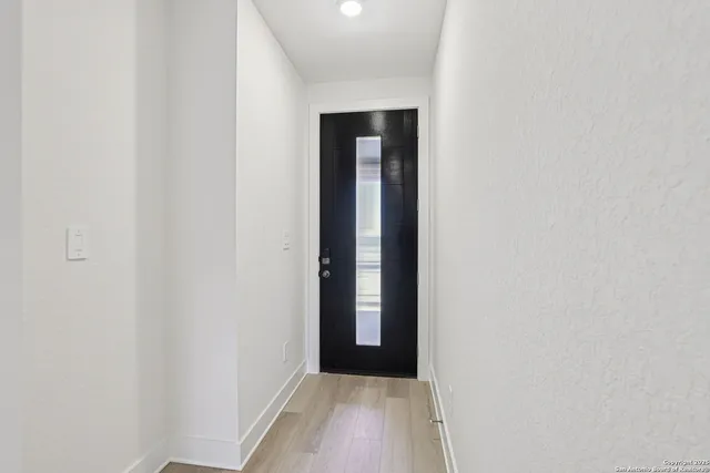 a view of an empty room with closet and a window