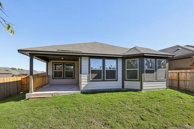 a view of a backyard with potted plants and wooden fence