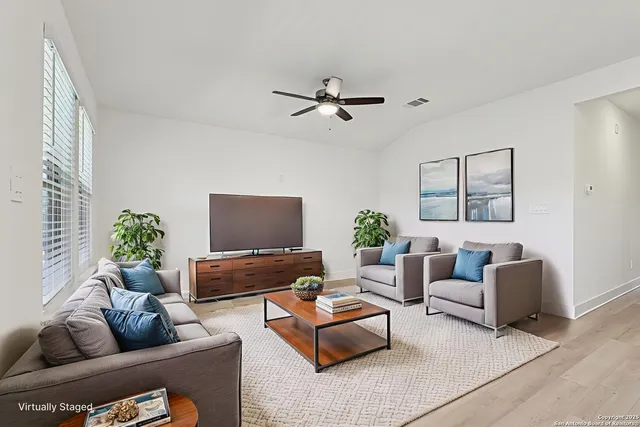 a living room with furniture and a potted plant
