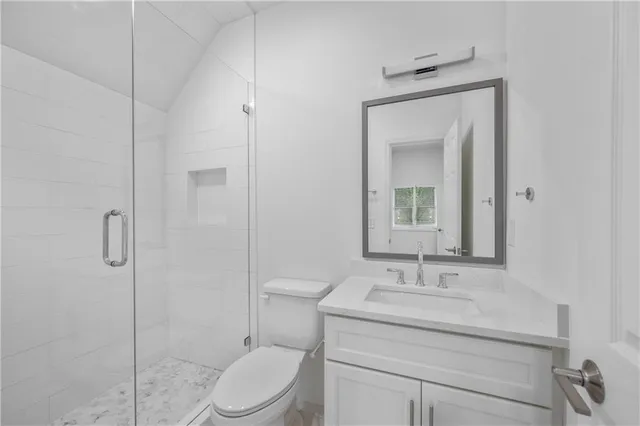 a bathroom with a granite countertop toilet a sink and a mirror