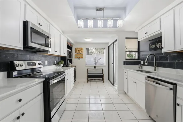a kitchen with stainless steel appliances granite countertop a stove top oven a sink dishwasher and a refrigerator