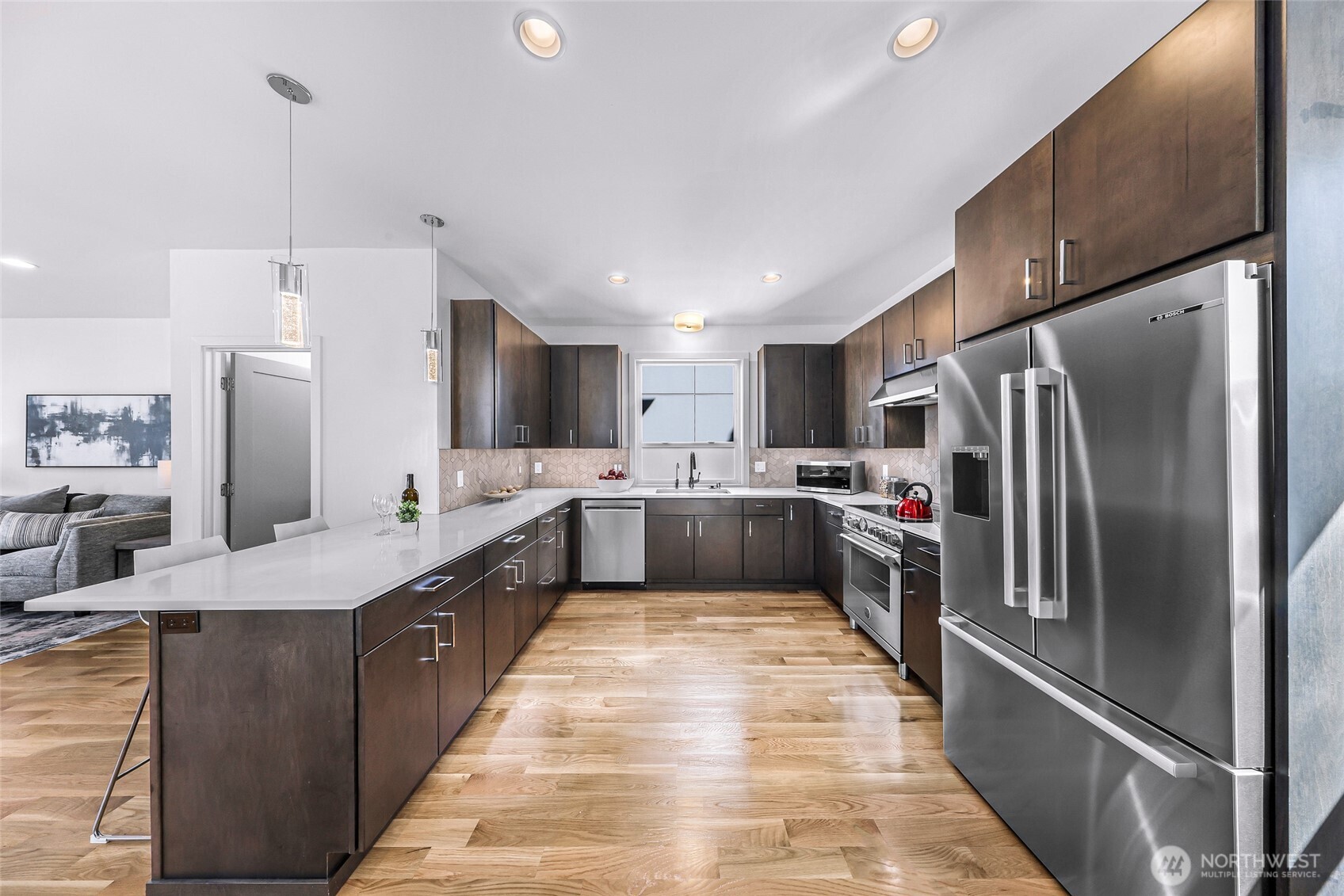 4218 Linden Avenue North Seattle, WA 98103 - Photo 12 of 38 a large kitchen with stainless steel appliances kitchen island a large counter top a sink a refrigerator and a cabinets