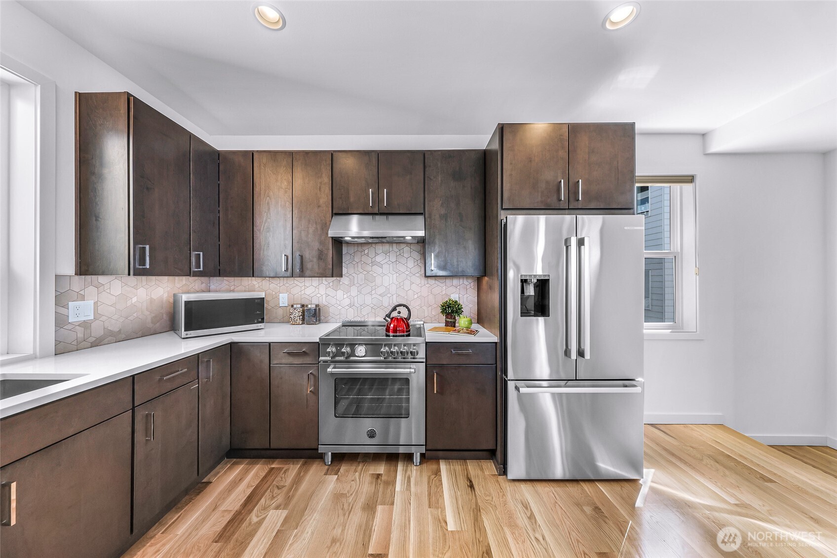 4218 Linden Avenue North Seattle, WA 98103 - Photo 14 of 38 a kitchen with a refrigerator a stove and wooden floors