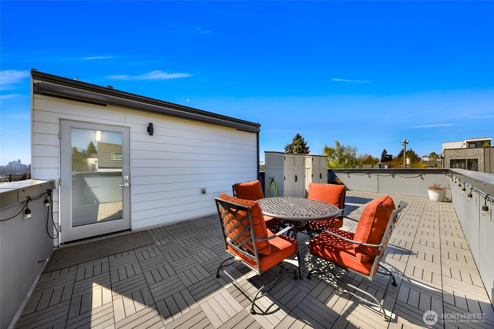 4218 Linden Avenue North Seattle, WA 98103 - Photo 29 of 38 a view of a roof deck with table and chairs with wooden floor and fence