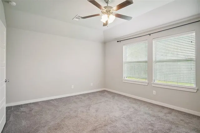an empty room with a window and a fan