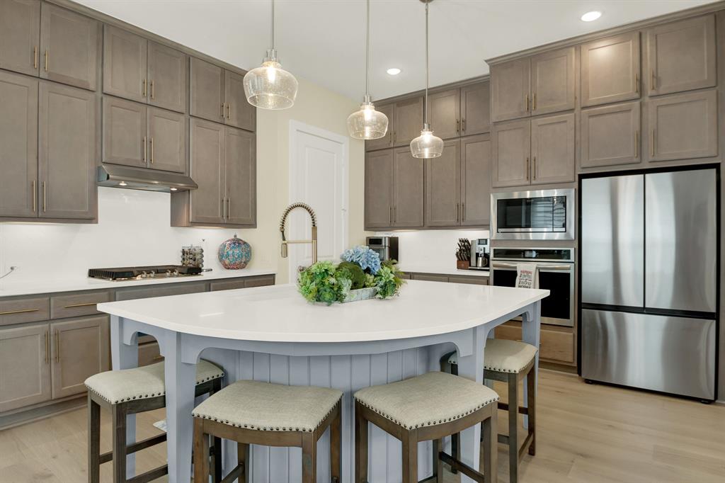 a kitchen with stainless steel appliances a table chairs and a refrigerator