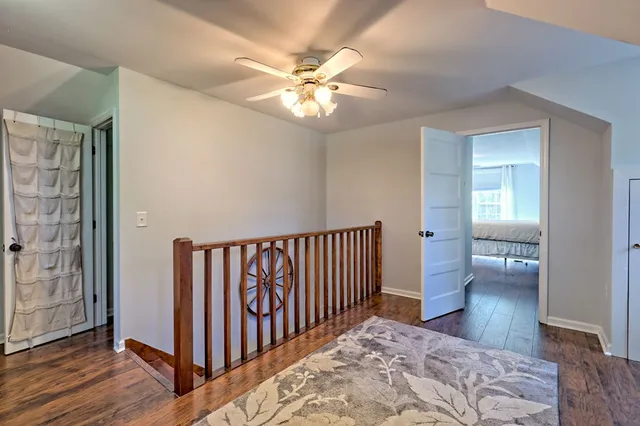 a spacious bedroom with a bed a chandelier and dresser