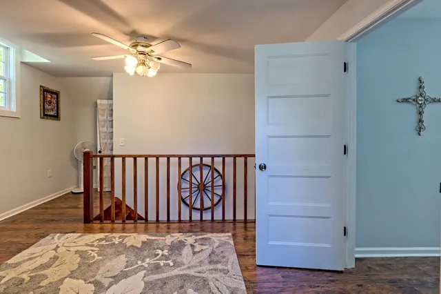 a view of a hallway with wooden floor and staircase