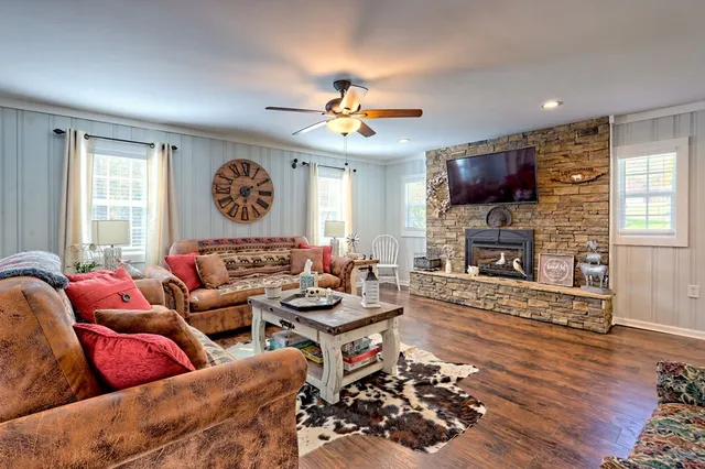 a living room with furniture a fireplace and a window