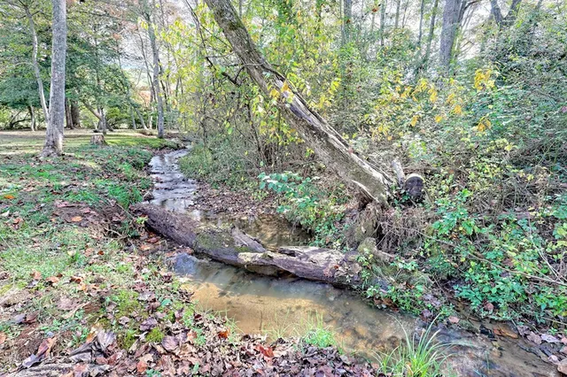 a backyard of a house with lots of green space and lake view
