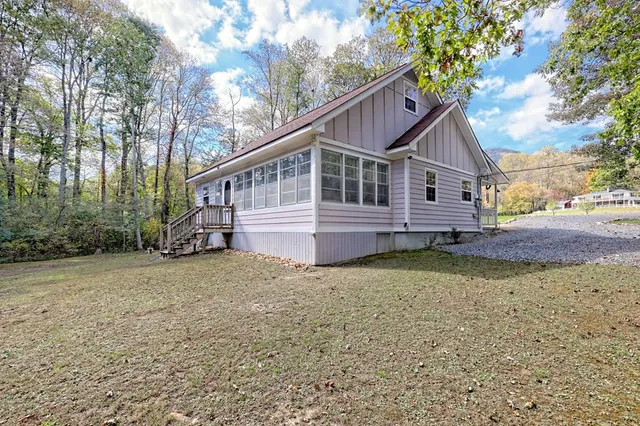 a view of a house with a yard and tree s