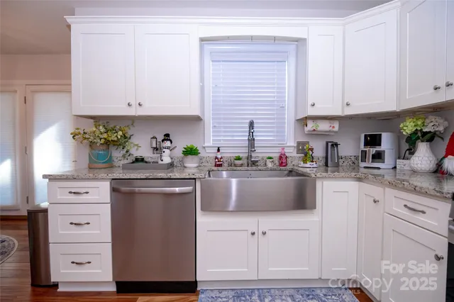 a kitchen with granite countertop white cabinets and white appliances