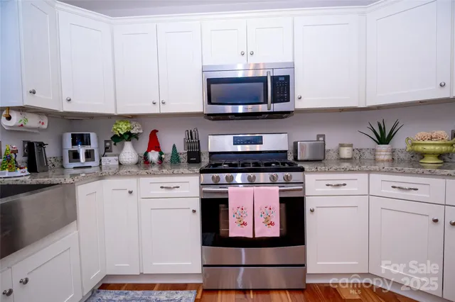 a kitchen with stainless steel appliances granite countertop a stove a microwave and cabinets