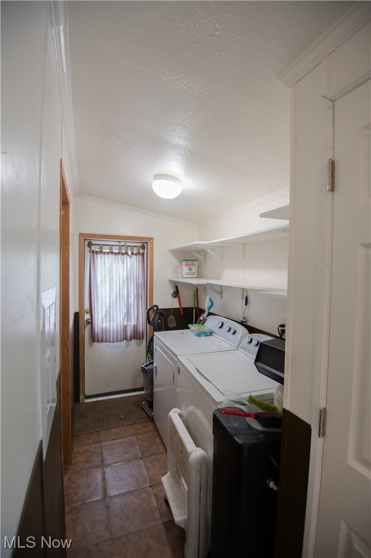 4594 Center Road Andover, OH 44003 - Photo 20 of 39 Laundry room featuring a textured ceiling, washer and clothes dryer, and dark stone finish flooring