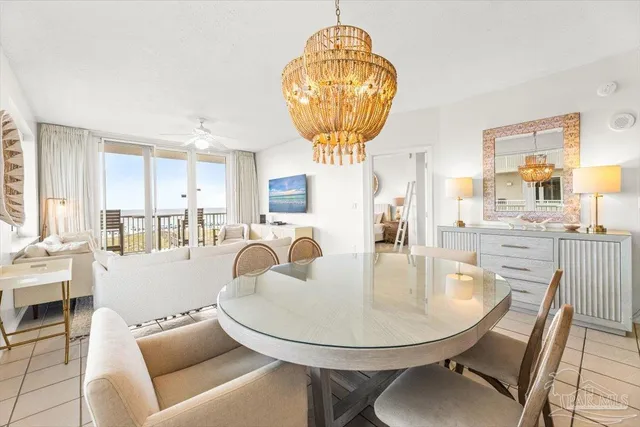 a living room with furniture a chandelier and kitchen view