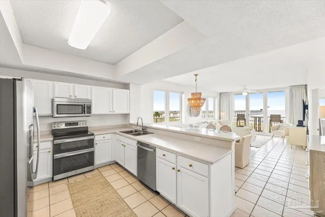 a kitchen with stainless steel appliances granite countertop a sink a stove a refrigerator and a window