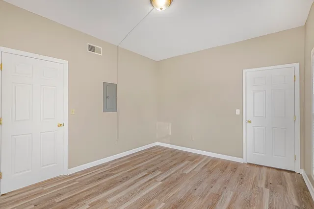 a view of an empty room with wooden floor