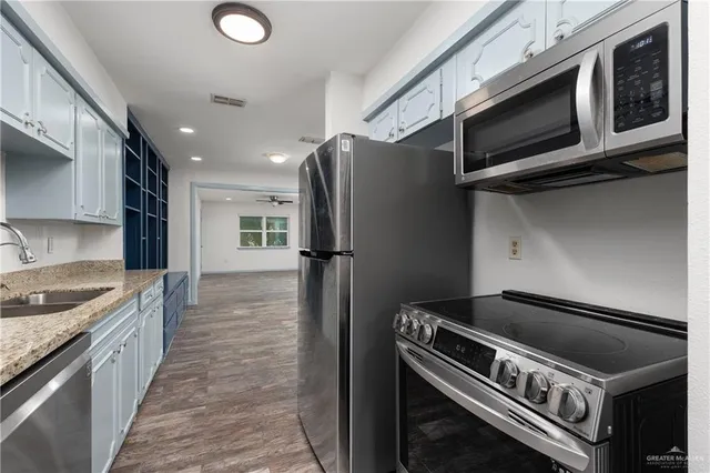 a bathroom with a granite countertop sink a toilet and mirror