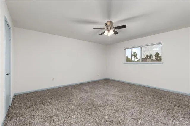 a view of an empty room and a ceiling fan