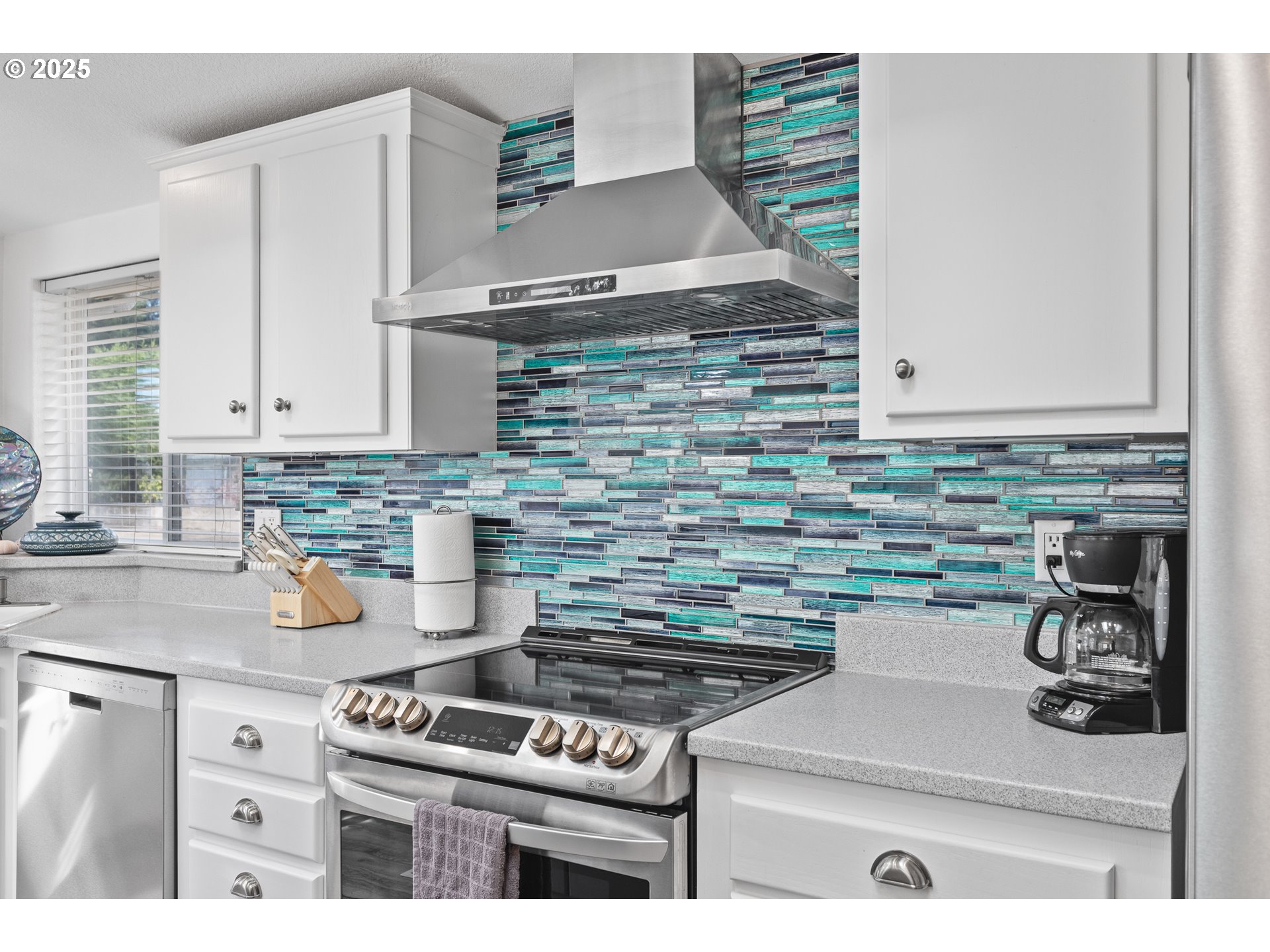 852 Munsel Creek Loop Florence, OR 97439 - Photo 19 of 48 a kitchen with a stove and white cabinets