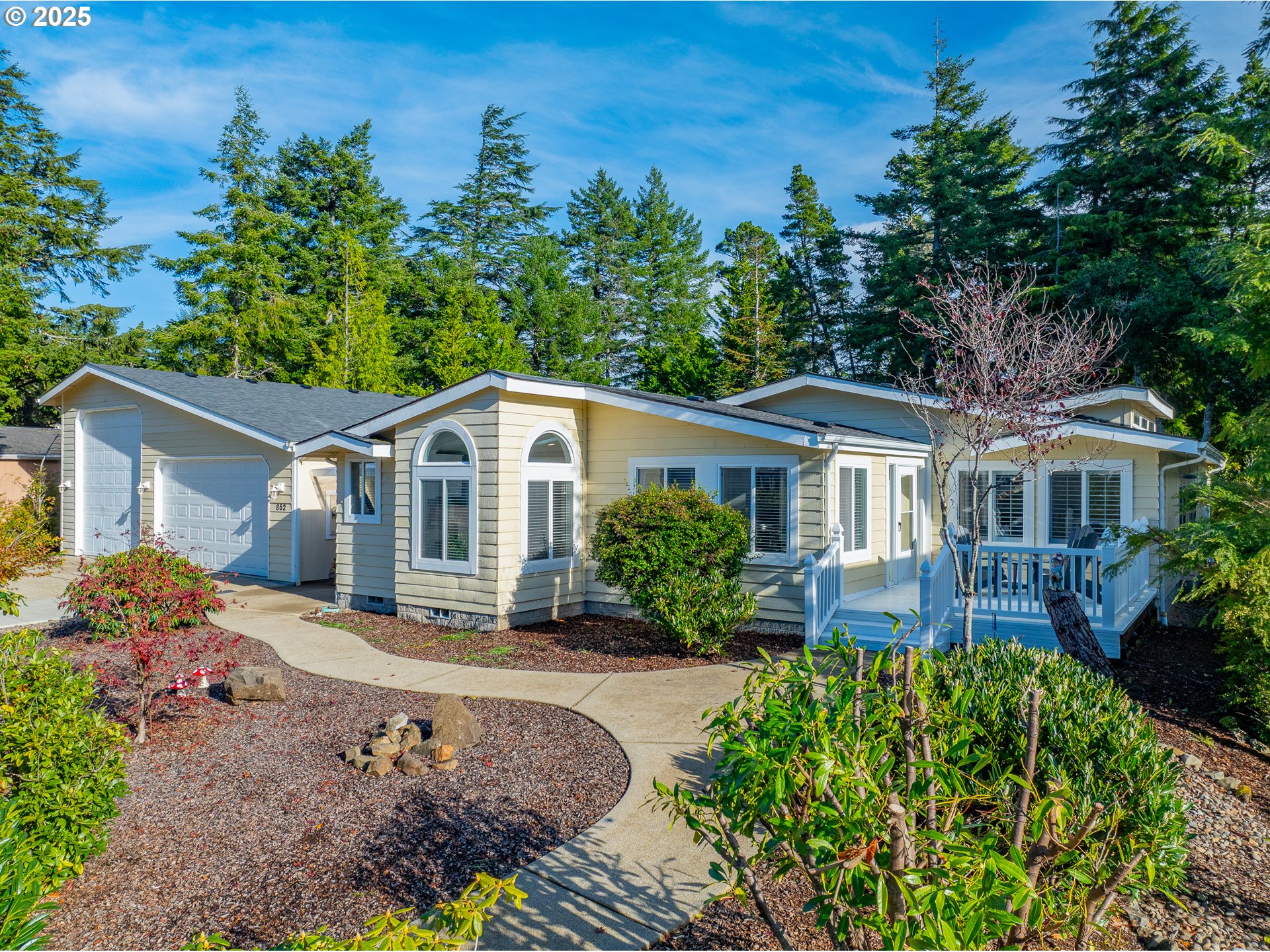 852 Munsel Creek Loop Florence, OR 97439 - Photo 2 of 48 a front view of a house with a garden