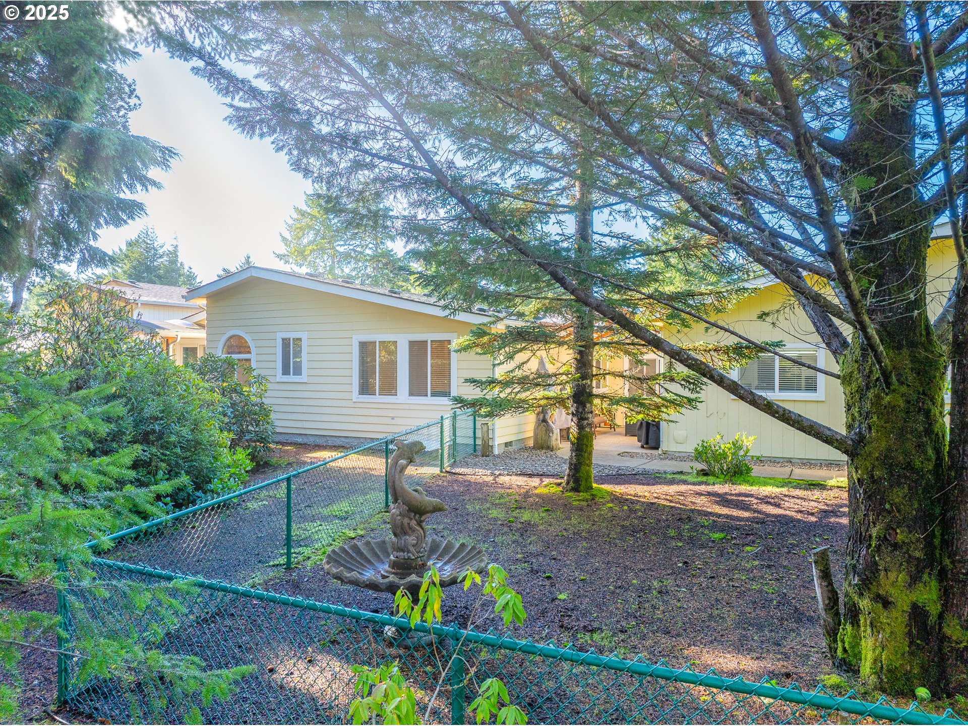 852 Munsel Creek Loop Florence, OR 97439 - Photo 7 of 48 a backyard of a house with lots of green space and fountain