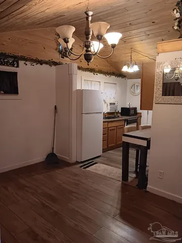 a kitchen with a refrigerator a stove and wooden floor