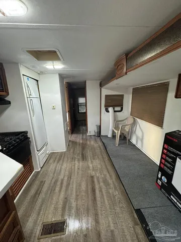 a view of a bedroom with wooden floor and furniture