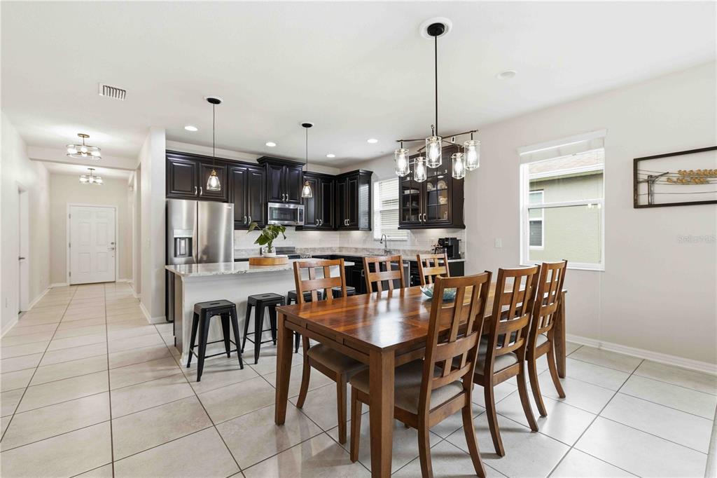 10920 79th Street East Parrish, FL 34219 - Photo 12 of 73 a dining area with a table chairs and a kitchen view