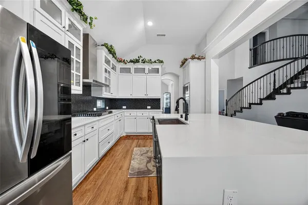 a large white kitchen with stainless steel appliances