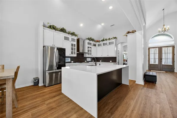 a large kitchen with a wooden floor and a refrigerator