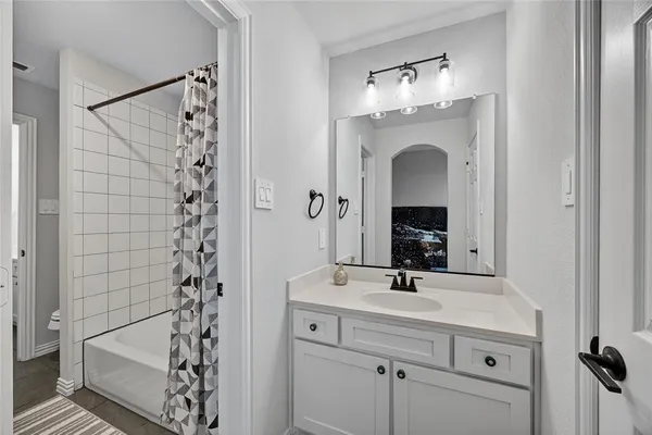 a bathroom with a sink shower and a mirror